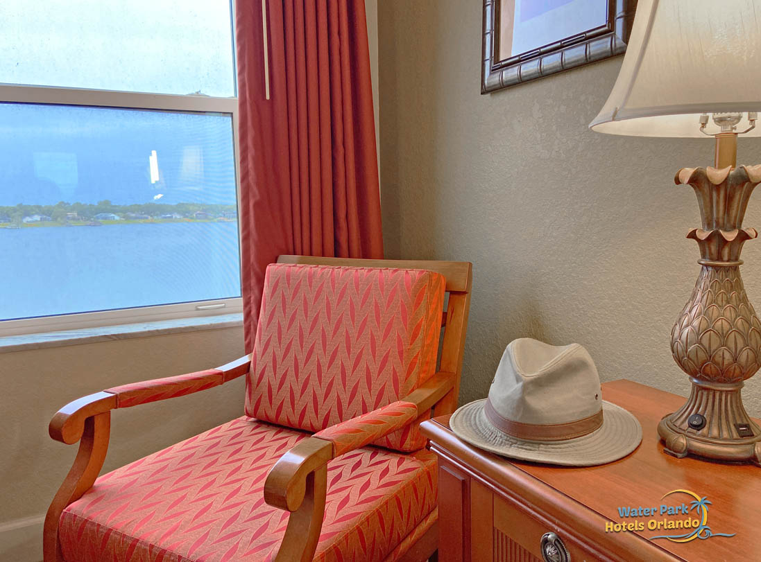 a warm red chair near a window with a view of Big Sand Lake in the deluxe one bedroom villa at Westgate Lakes 