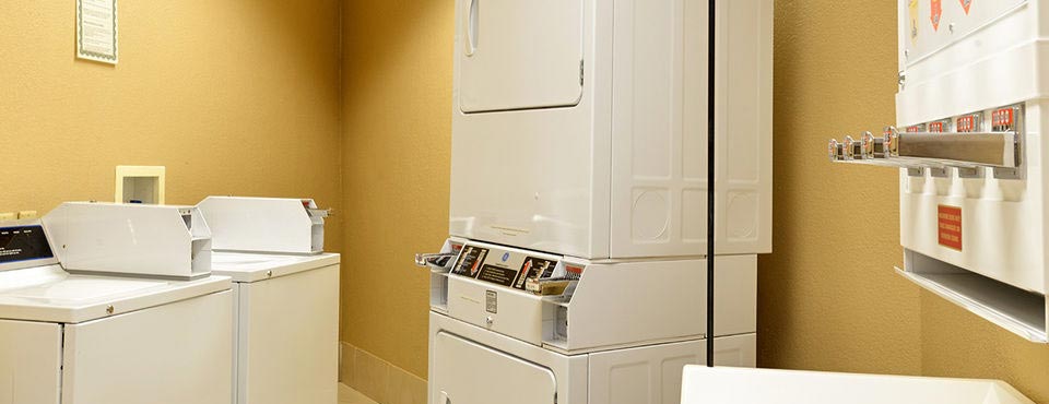 Laundry room with full size washer and dryer at the Comfort Inn Orlando Lake Buena Vista Hotel