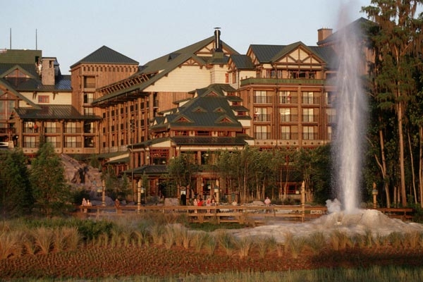View of the back of Disney Wilderness Lodge with view of spraying geiser in background 600