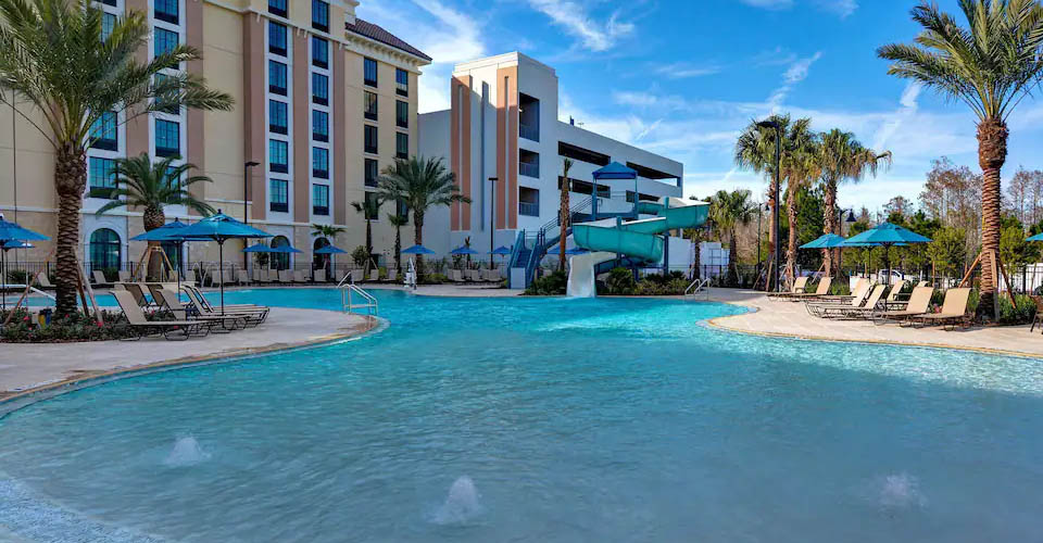 Large Outdoor Pool with zero-entry and water slide in background at the Home2 Suites in Flamingo Crossing a Hilton Hotel 960