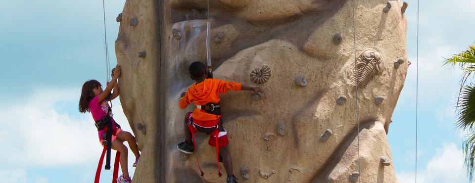 The Rock Climbing Wall at the Buccaneer Bay Adventure Park with kids climbing their way to the top at Summer Bay Resort in Orlando Fl