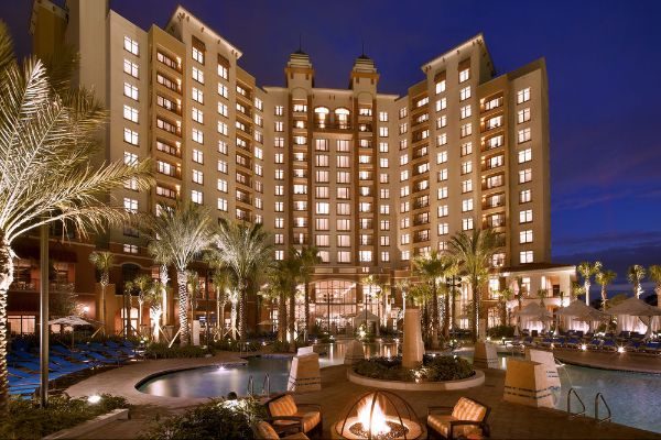 Evening View of the Wynham Grand Orlando at Bonnet Creek lit up from the Pool with Cabanas in the background 600